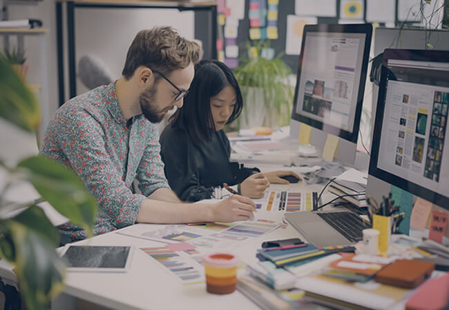 Graphic artists working together on a design.