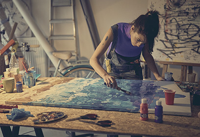 Female painting on large canvas in a studio