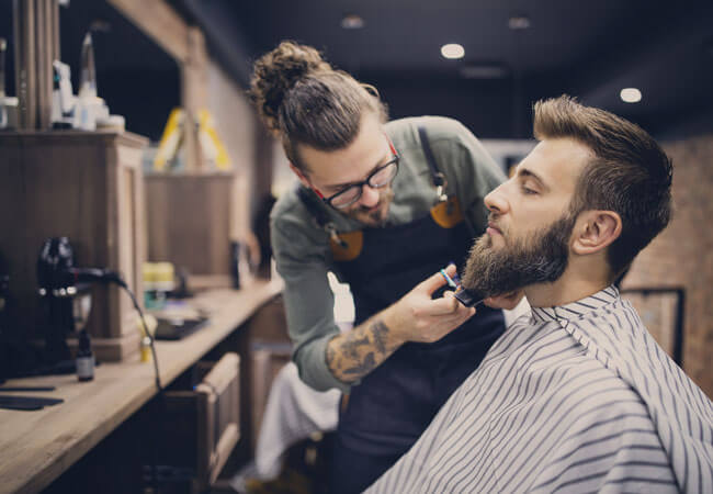 Man getting his beard trimmed at a barber shop