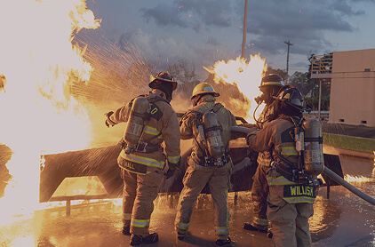 Firefighters putting out a burning car