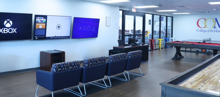 Student recreation room showing a pool table, arcade game, and video game station.